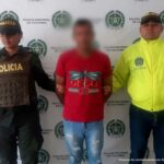 En la imagen se ve un hombre con camiseta roja capturado, en medio de un policía y un funcionario del CTI.