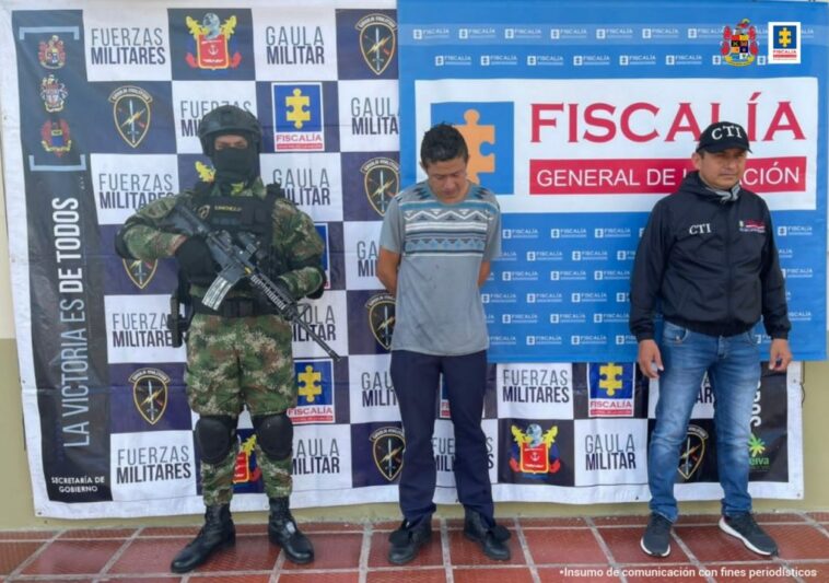 En las fotografía aparece un capturado, junto a personal de CTI y Ejército Nacional. En la parte posterior de la imagen se ven banners de Ejército Nacional y la Fiscalía General de la Nación.