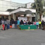 Se observan 17 personas capturadas, todas de espaldas y en fila.  En ambos costados personal de la Policía y del CTI de la Fiscalía General de la Nación.  Igualmente se ven dos caninos que acompañaron los operativos.  En el centro una mesa con mantel verde en la que se encuentra el material incautado durante las capturas.