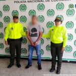 La persona capturada aparece con sus manos esposadas y está custodiado por dos miembros de la policía, tiene su cara pixelada para proteger la identidad de la vítima menor de edad.