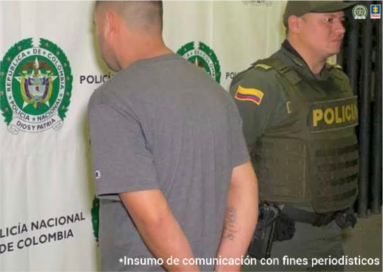 En la foto se aprecia al hoy asegurado de espalda siendo custodiado por un miembro de la Policía.