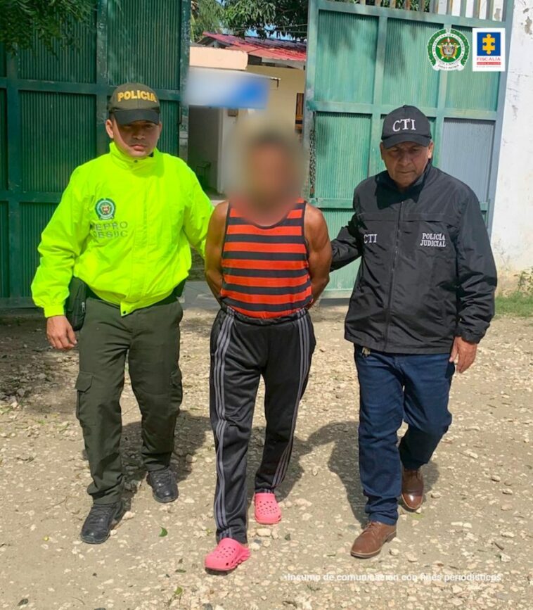En la imagen se observa cuando es capturado el procesado con camiseta de rallas rojas con negra y una sudadera negra custodiado por un uniformado del CTI y un uniformado de la Policía Nacional.