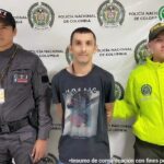 En la foto aparece Jorge Luis Velásquez Galeano, alias ‘Vampiro’ o ‘Maluma’, vestido con una camiseta negro con estampado. Al lado derecho de él hay un servidor del CTI de la Fiscalía y a su izquierda un uniformado de la Policía Nacional. Detrás de ellos un pendón institucional de la Policía.