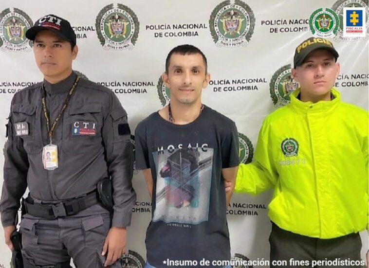 En la foto aparece Jorge Luis Velásquez Galeano, alias ‘Vampiro’ o ‘Maluma’, vestido con una camiseta negro con estampado. Al lado derecho de él hay un servidor del CTI de la Fiscalía y a su izquierda un uniformado de la Policía Nacional. Detrás de ellos un pendón institucional de la Policía.