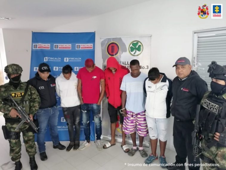 En la foto se observan a 5 de los asegurados junto a dos servidores del CTI y dos soldados del Ejército Nacional. En la parte superior se observan un banner de la Fiscalía General y un banner del Ejército Nacional