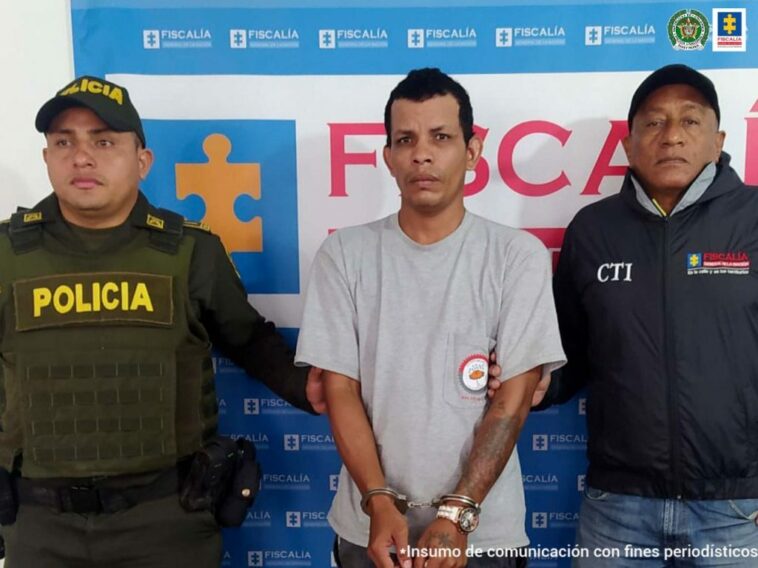 En la fotografía aparece un hombre capturado, junto a un servidor del CTI y un uniformado de la Policía Nacional, en la parte posterior un banner de la Fiscalía General del Nación.