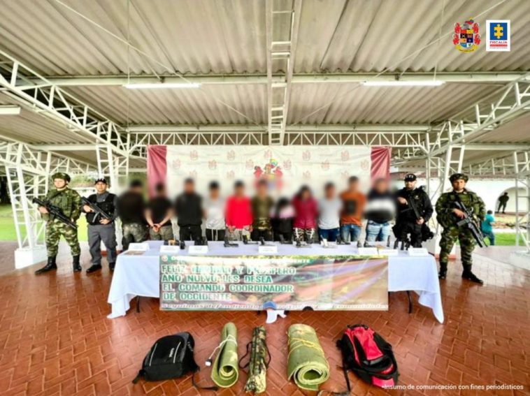 En la foto aparecen los presuntos integrantes del Gaor Carlos Patiño. A lado y lado de los judicializados hay personal uniformado del CTI de la Fiscalía, Policía y Ejército. Delante de ellos hay una mesa con mantel blanco y sobre ella se exponen algunos de los elementos incautados. Asimismo, sobre el suelo hay otros elementos incautados. Detrás de los hoy imputados hay un pendón institucional del Ejército.