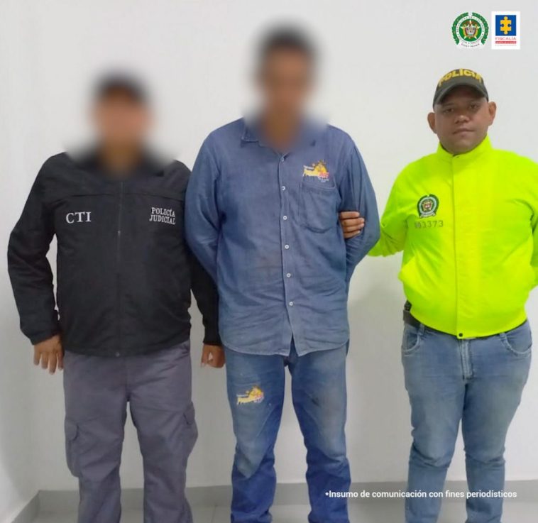 En la imagen se ve una persona capturada entre un funcionario de la Policía y uno de la Fiscalía.