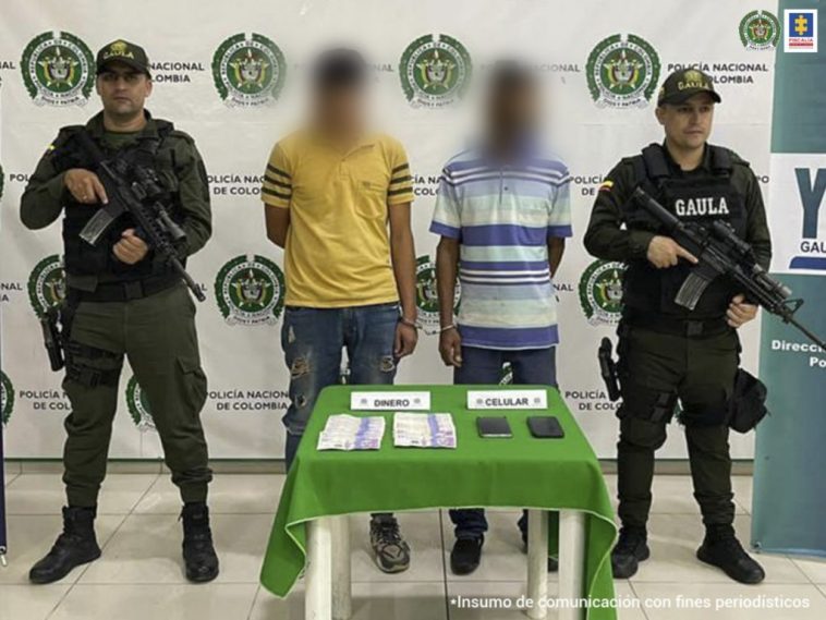 En la foto aparecen los dos asegurados siendo custodiados por la Policía Nacional.