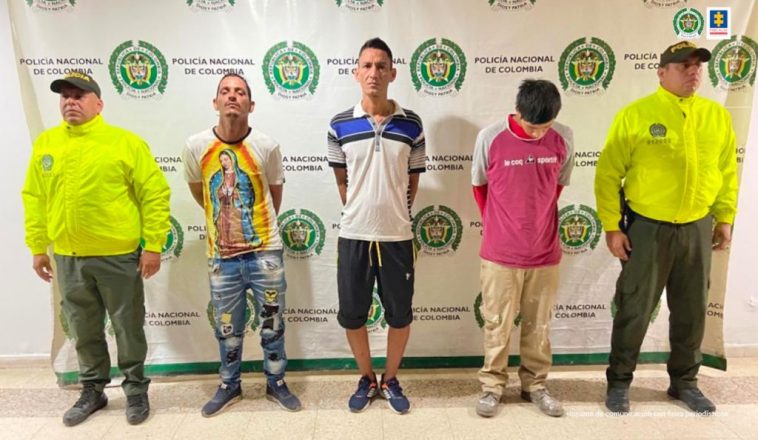 En las fotografía aparecen tres capturados junto a personal de Policía Nacional. En la parte posterior de la imagen se ven banners de Policía Nacional y la Fiscalía General de la Nación.