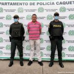 En la imagen se ve una persona detenida custodiada por dos uniformados de la Policía Nacional.