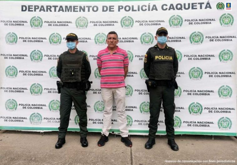 En la imagen se ve una persona detenida custodiada por dos uniformados de la Policía Nacional.