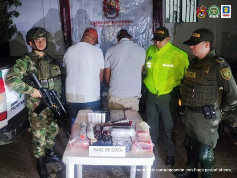 En la fotografía se observan a los dos capturados de espaldas junto a uniformados del Ejército y de la Policía Nacional. Frente a ellos una mesa con la base de coca incautada. En la parte posterior se aprecia banner que identifica al Ejército Nacional.