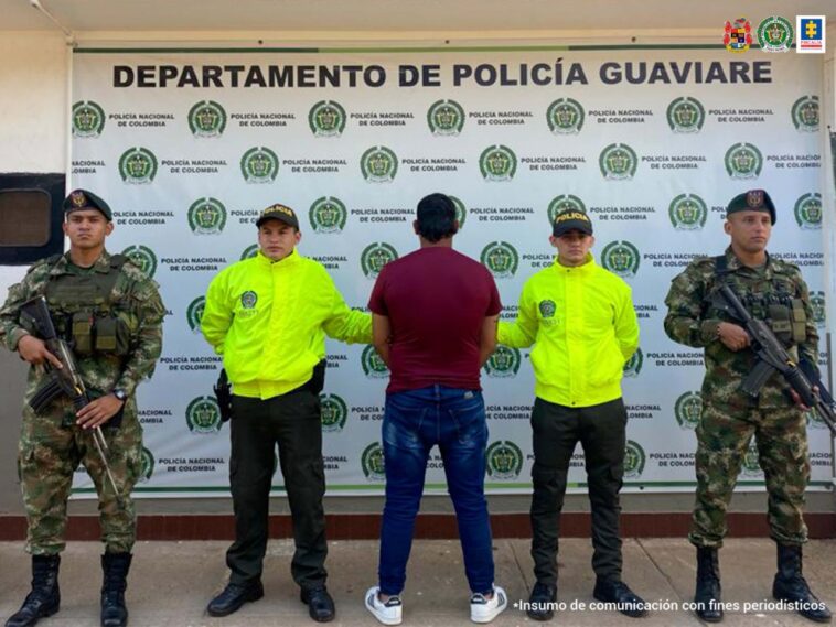 El capturado aparece en el centro de la imagen, de espaldas. Lo acompañan dos uniformados de la Policía y dos del Ejército.