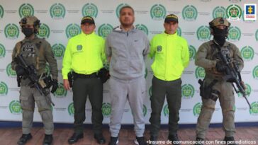 En la imagen se ve una persona detenida entre cuatro uniformados de la Policía.