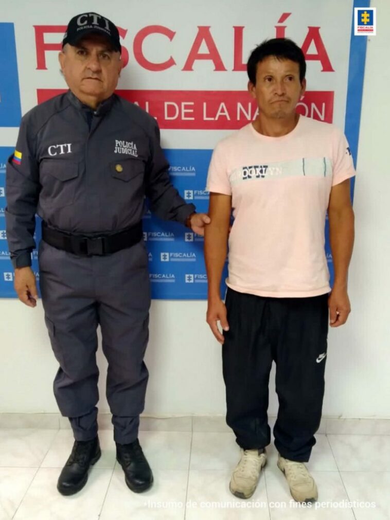 En la fotografía aparecen tres capturados, junto a personal de Policía Nacional y  Fiscalía General de la Nación. En la parte posterior de la imagen se ven banners de Policía Nacional y la Fiscalía General de la Nación.