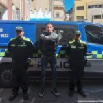 En la fotografía se observa al capturado junto a dos agentes de la Policía Nacional.   En la parte superior se observa una radiopatrulla de la Policía