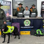 En la fotografía aparece un capturado, junto a personal de Policía Nacional y Fiscalía General de la Nación. En la parte posterior de la imagen se ven banners de Policía Nacional y la Fiscalía General de la Nación.