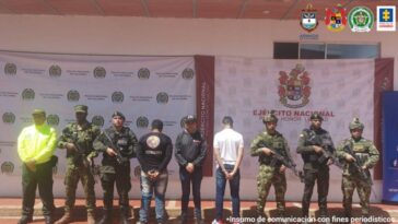 Los capturados aparecen de espalda, están custodiados por hombres de la Fiscalía, el Ejército, la Armada de Colombia y la Policía Nacional.