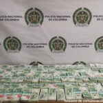 Fotografía de dinero incautado, el cual está organizado sobre una mesa y distribuido en varios fajos de billetes de 100.000 pesos.
