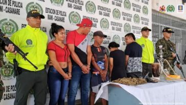 Los cinco capturados, dos mujeres y tres hombres aparecen custodiados por hombres de la Policías y del Ejército nacional y en una mesa todos los elementos incautados entre ellos una pistola traumática y marihuana.