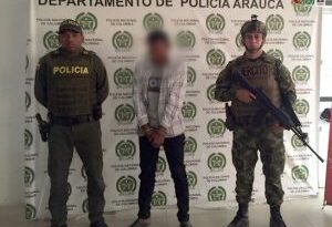 En la fotografía aparece el procesado junto a uniformados de la Policía y del Ejército Nacional. En la parte posterior se aprecia el banner que identifica al Departamento de Policía de Arauca.