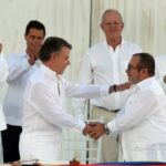ARCHIVO - En esta foto de archivo de septiembre de 2016, el presidente de Colombia, Juan Manuel Santos, y el comandante de las Fuerzas Armadas Revolucionarias de Colombia, FARC, Rodrigo Londoño, se se saludan en el marco de la firma del acuerdo de Paz en La Habana, Cuba.