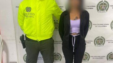 En la imagen aparece la procesada y junto a ella un patrullero de la Policía Nacional.