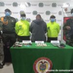 En la imagen el hombre capturado acompañado de Policía y Ejército, además una mesa con el material incautado entre droga, dinero y celulares
