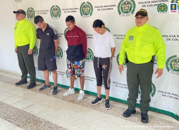 En la fotografía aparecen tres capturados, junto a personal de Policía Nacional. En la parte posterior de la imagen se ven banners de Policía Nacional y la Fiscalía General de la Nación.