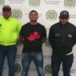 Un investigador del CTI y un uniformado de la Policía Nacional custodian al procesado tras su captura por el delito de homicidio.