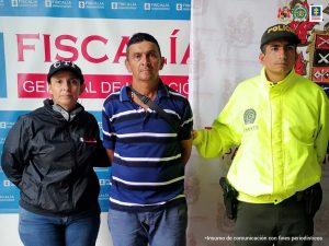 En la foto aparece, de pie y con los brazos atrás, Héctor Hernando Nieto Cristancho. Viste camisa de manga corta con rayas anchas azules y blancas delgadas; así como pantalón azul. Al lado derecho de él hay una servidora del CTI de la Fiscalía y a la izquierda un uniformado de la Policía Nacional. Detrás de ellos hay dos pendones institucionales de la Fiscalía y del Ejército.