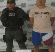 En la imagen se ve una persona detenida, junto con un uniformado de la Policía.