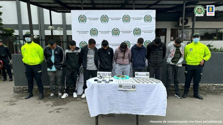 En la imagen los capturados, al frente una mesa con elementos incautados   acompañados de dos uniformados de la policía Nacional