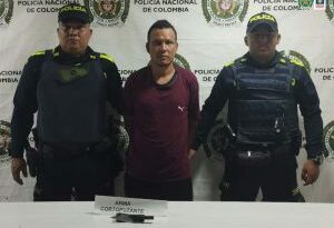 Dos uniformados de la Policía Nacional custodian al procesado (de camisa vino tinto). En la mesa se encuentra el arma cortopunzante con la que se presume habría cometido el crimen.