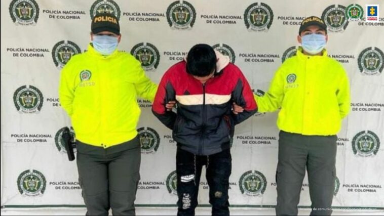 En la fotografía se observa al capturado junto a dos agentes de la Policía Nacional. En la parte superior se observa un banner de la Policía Nacional