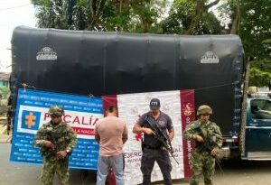 En la foto, los tres capturados con un servidor CTI y un soldado del ejército nacional.  Arriba, camiones cargados de caña de azúcar robada