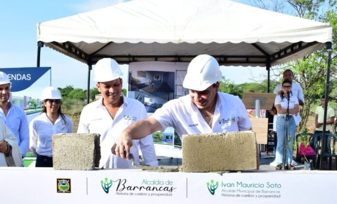 El alcalde con el palaustre en la mano, colocándole mezcla al bloque, en señal de la primera piedra del proyecto que comienza a construir 200 viviendas para sus habitantes.