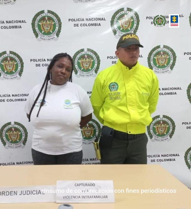 En la fotografía aparece la capturada junto a un agente de la Policía Nacional En la parte superior está un banner de la Policía Nacional