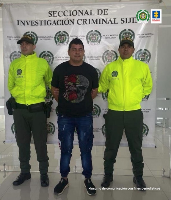 En la imagen se aprecia el capturado junto a uniformado de la Policía. En la parte posterior se observa el banner que identifica a la Seccional de Investigación Criminal Sijin de la Policía Nacional.