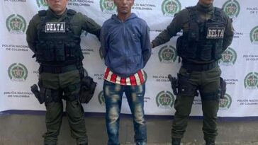 Dos funcionarios de la Policía Nacional custodian al hombre, de 40 años de edad, señalado de llevar en 39 costales más de 300 babillas.