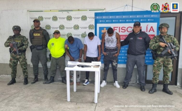 En la fotografía están los tres capturados junto a un servidore del CTI, un agente de la Policía Nacional y dos soldados del Ejército. En la parte posterior aparece una mesa con las tres armas, dos proveedores, munición y teléfonos celulares