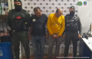 En la fotografía se observa a dos de los capturados junto a dos unidades del GOES de la Policía Nacional. En la parte superior está un banner de la Policía Nacional