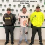 En la imagen se aprecia al capturado junto a dos uniformados de la Policía Nacional. Detrás de ellos un banner que identifica al Departamento de Policía en Tame (Arauca)