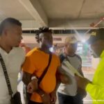 En la fotografía se observan cuatro personas, una de ellas el capturado que lleva una camiseta anaranjada, acompañado de dos Policías de civil y un policía con su respectivo uniforme que le está leyendo los derechos del capturado.
