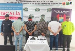 En la imagen se ven cuatro personas detenidas bajo custodia del CTI y la Policía Nacional. Detrás suyo backings institucionales.