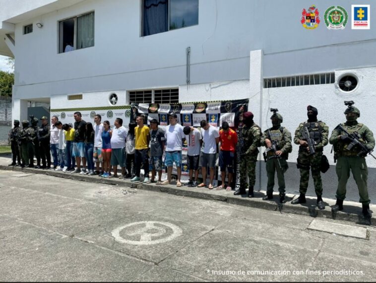 En la fotografía aparecen de frente los presuntos integrantes de la ‘Oficina La Inmaculada’.  A lado y lado de ellos hay uniformados de la Policía Nacional y del Ejército. Detrás de ellos hay dos pendones institucionales, uno de la Policía y otro con logos del Ejército, Fiscalía y Gaula Militar.