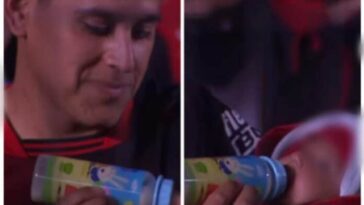 Un hincha del Colón alimentando a su bebé en el estadio, durante el partido