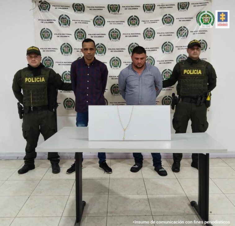 En la imagen se ven dos personas detenidas bajo custodia de la Policía Nacional. Detrás suyo un hacking institucional.