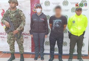 En la fotografía aparece el capturado junto con una servidora del CTI, un agente de la Policía y un soldado del Ejército. En la parte superior están un banner de la Policía Nacional